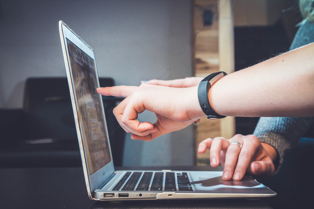 hands pointing to computer screen