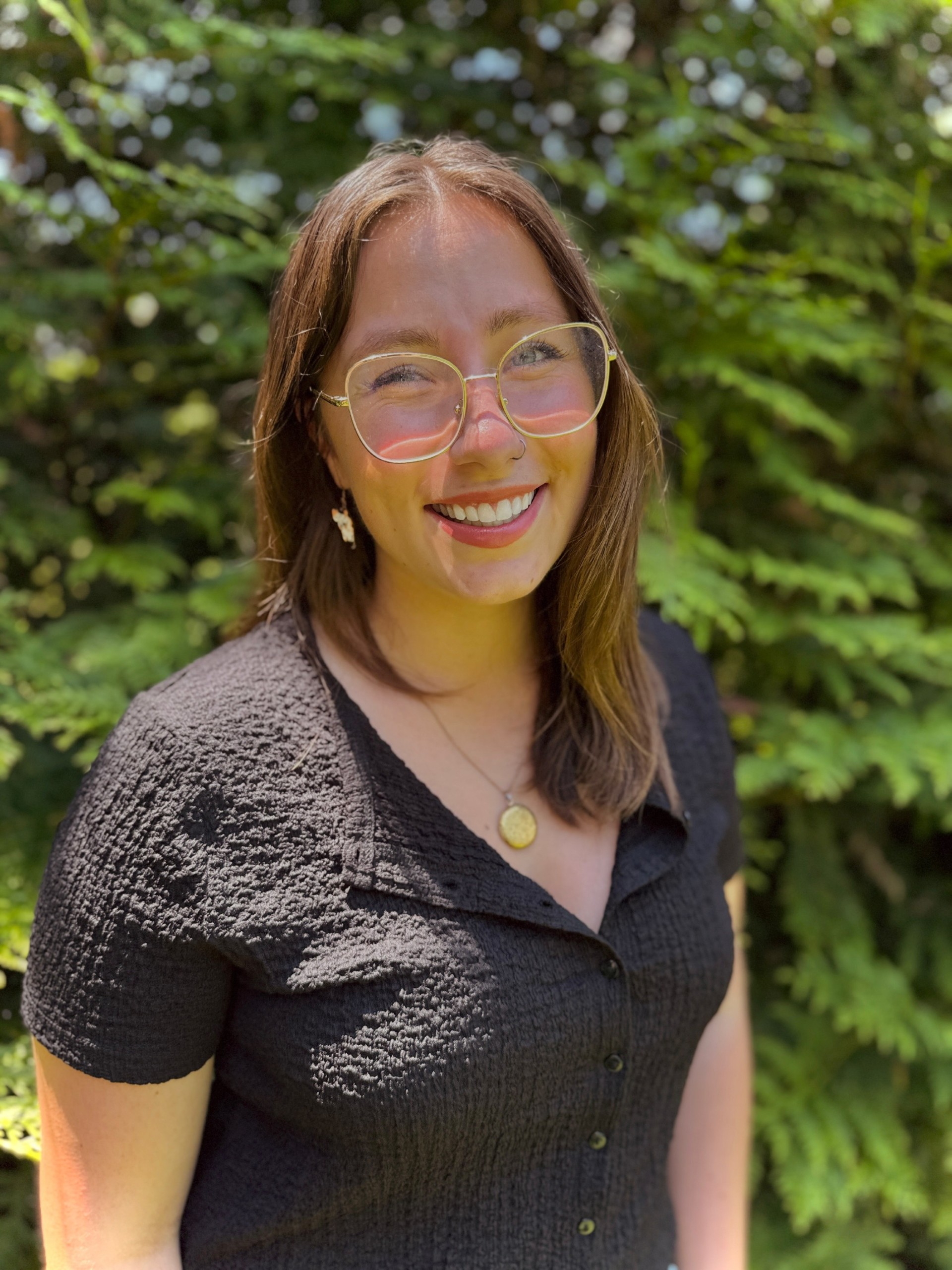 Becca Bussell smiling in a black shirt and glasses