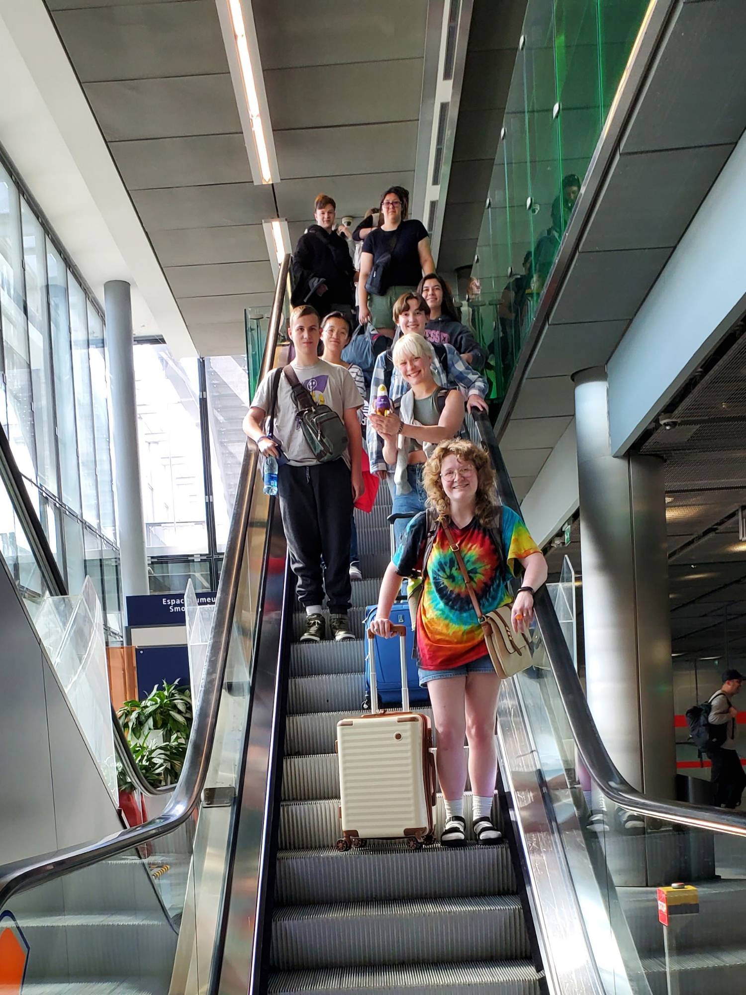 students with awesome stuffie on an escalator on a study abroad trip 