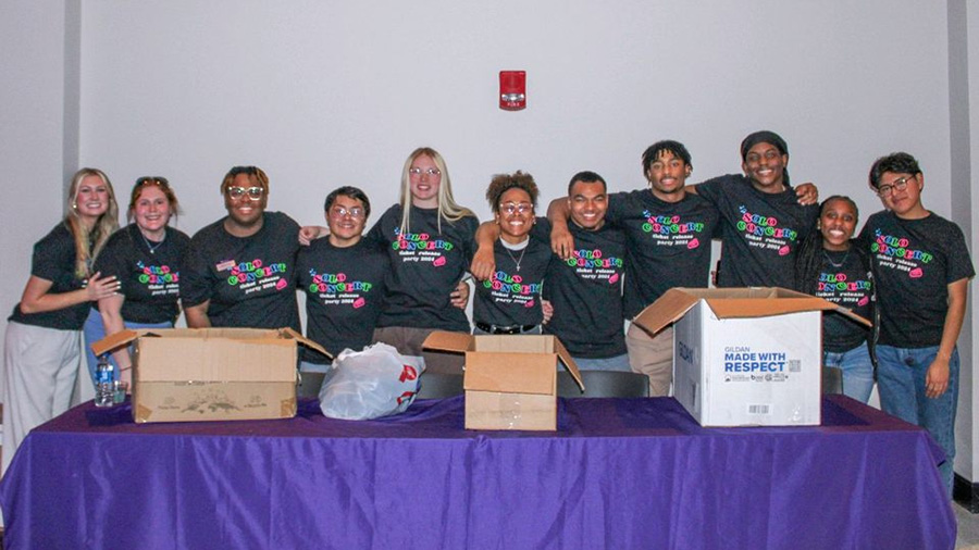 A group of students posing for the cameras as they set up an event.