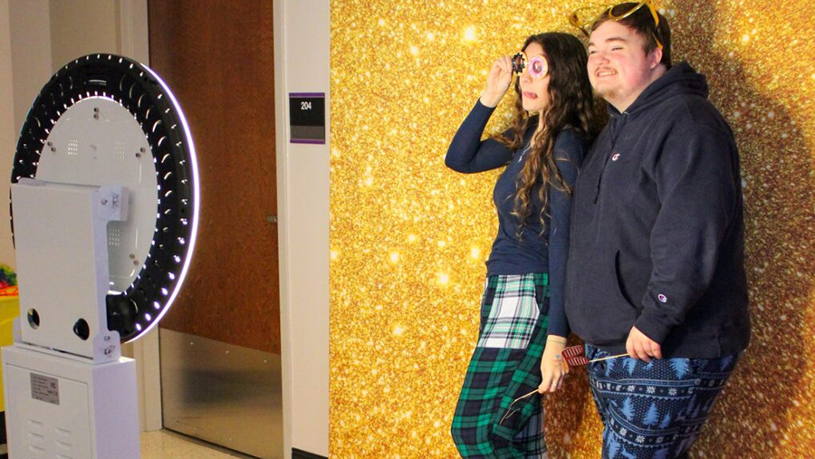 Two students having their photo taken in a photo booth.