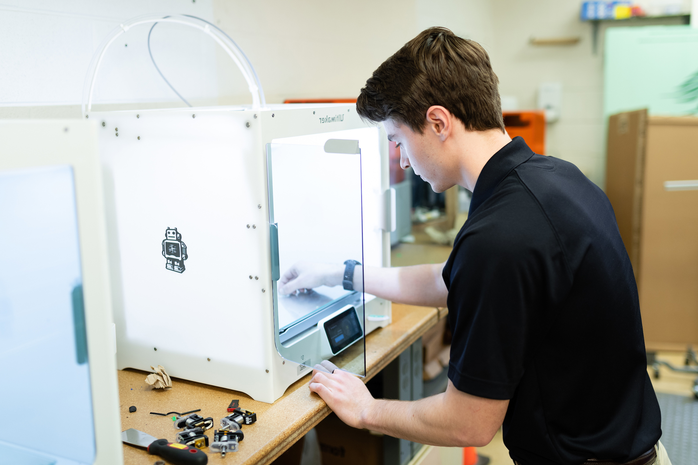 An Engineering student works on a 3D printer