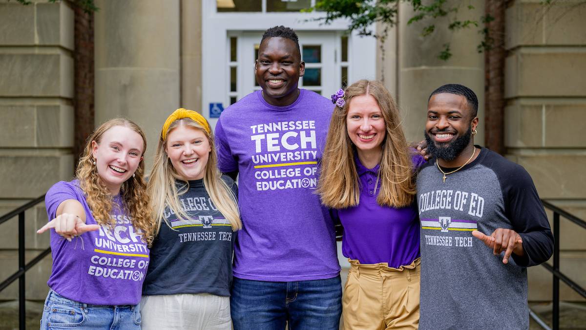 A group of students wearing Tech shirts smiling together