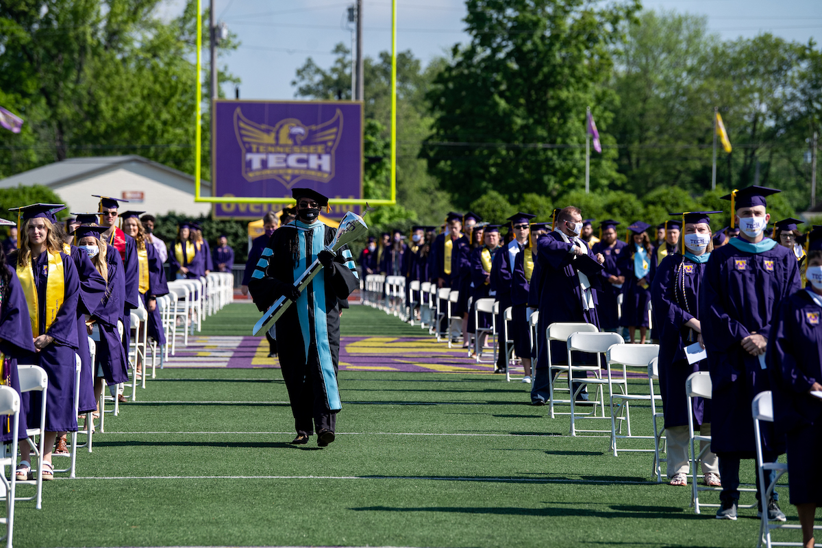 Carl Owens, a retiring professor in the College of Education & Human Sciences, led the procession as macebearer.