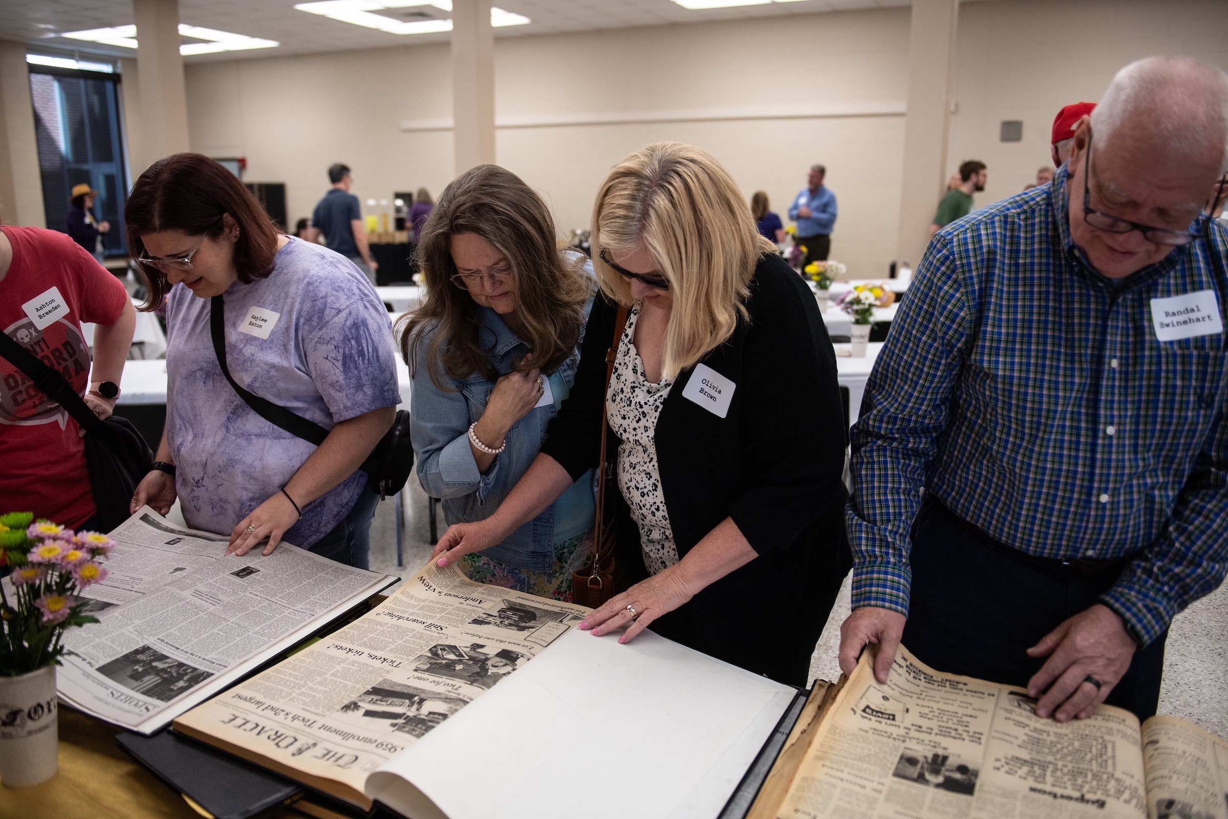 Oracle alumni pore over previous issues of the newspaper and other memorabilia.