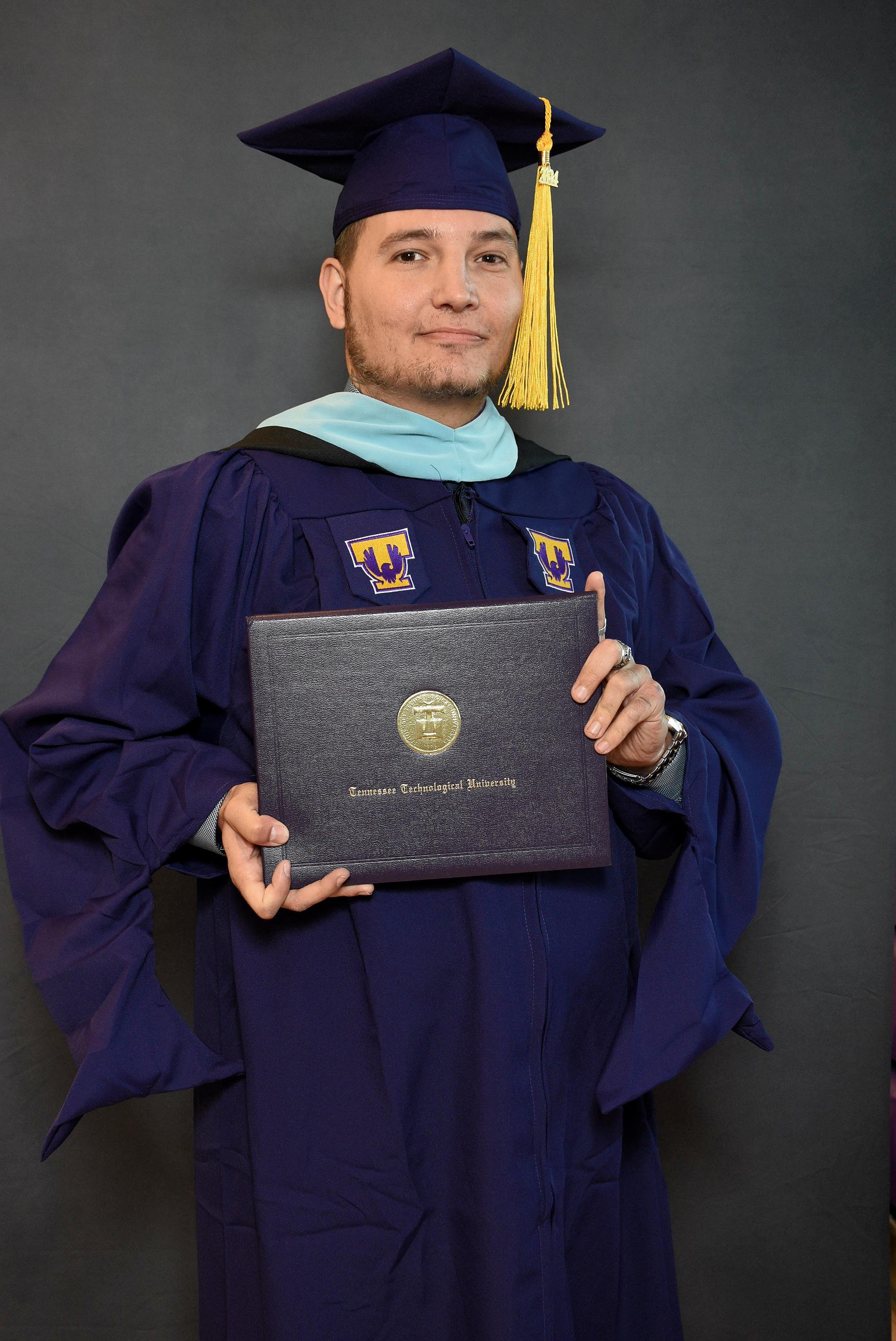 Rob Frazier in his regalia holding his degree from Tech